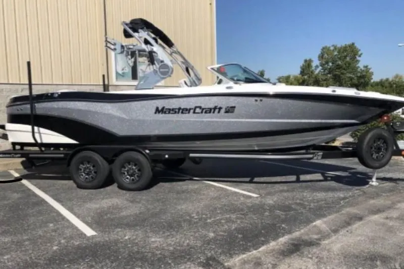 The Image of 2019 MasterCraft XT25 boat on trailer in parking lot, side view. - 1