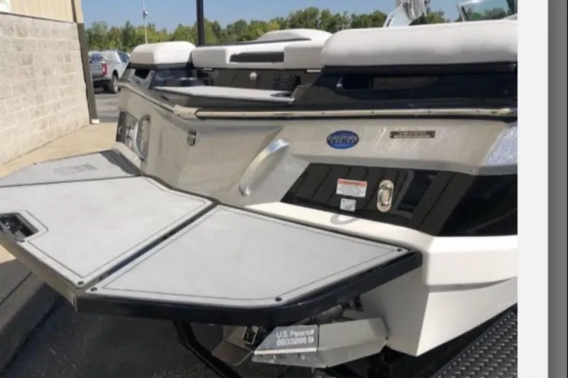 Slide: The Image of 2019 MasterCraft XT25 boat with open swim platform, parked outdoors. - 4