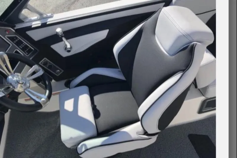 Slide: The Image of 2019 MasterCraft XT25 boat interior with sleek black and white captain's seat and steering wheel. - 7
