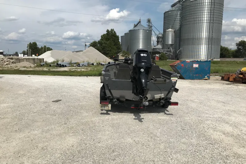 Slide: The Image of 2014 Lund 1650 Rebel XL SS boat with outboard motor in industrial setting. - 2