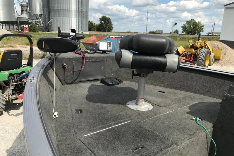 Slide: The Image of 2014 Lund 1650 Rebel XL SS boat interior with seat and equipment, near farm machinery. - 8