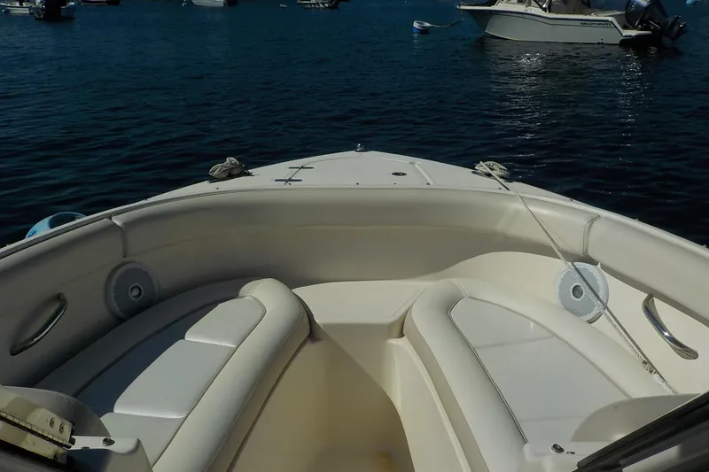 Slide: The Image of 2013 Pursuit DC 265 Dual Console boat interior with seating, on calm water. - 14