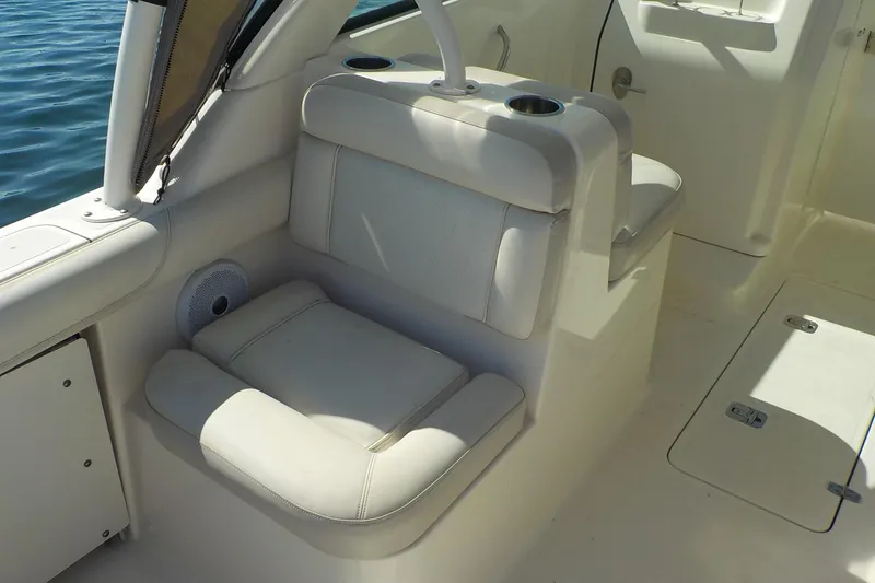 Slide: The Image of 2013 Pursuit DC 265 Dual Console boat interior with cushioned seating and cup holders. - 17