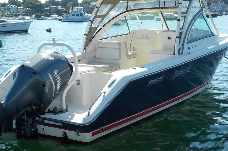 Slide: The Image of 2013 Pursuit DC 265 Dual Console boat with Yamaha outboard engine on water. - 2