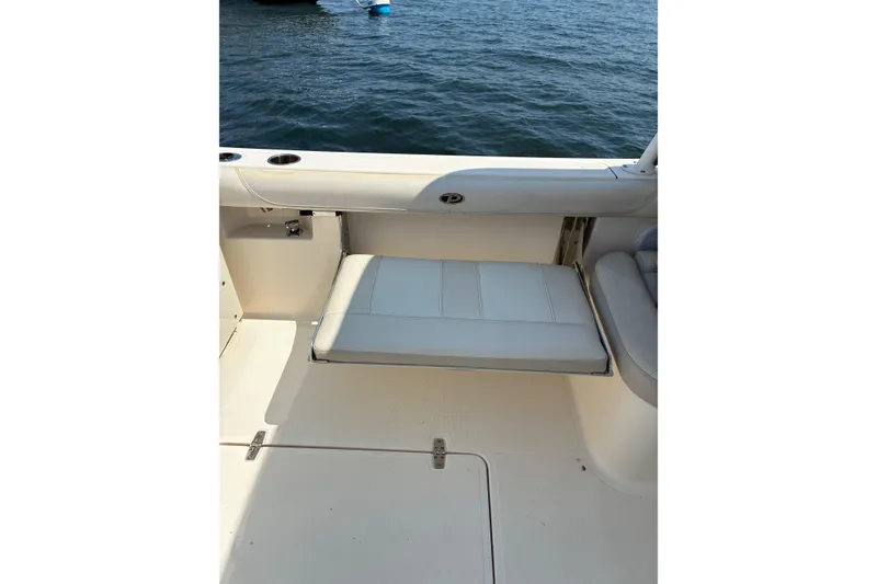 Slide: The Image of 2013 Pursuit DC 265 Dual Console boat with fold-down seat on deck. - 21