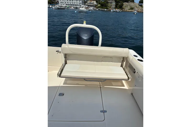 Slide: The Image of 2013 Pursuit DC 265 Dual Console boat with foldable seat, docked on calm water. - 23