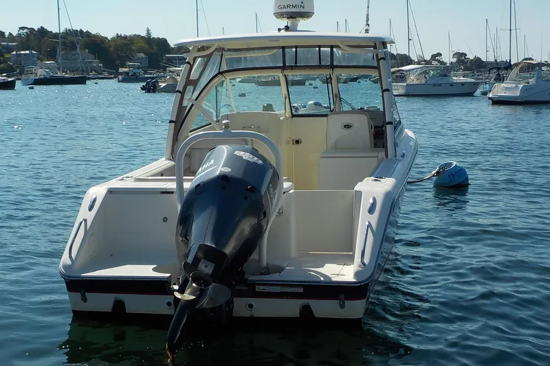 Slide: The Image of 2013 Pursuit DC 265 Dual Console boat on water, rear view with Yamaha engine. - 3
