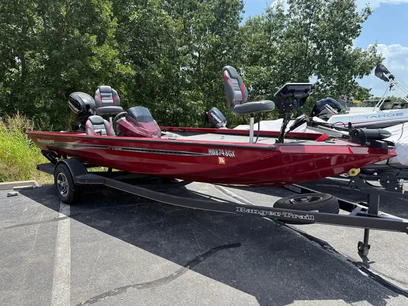 The Image of 2023 Ranger RT 188 boat in red on a trailer, parked outdoors. - 0
