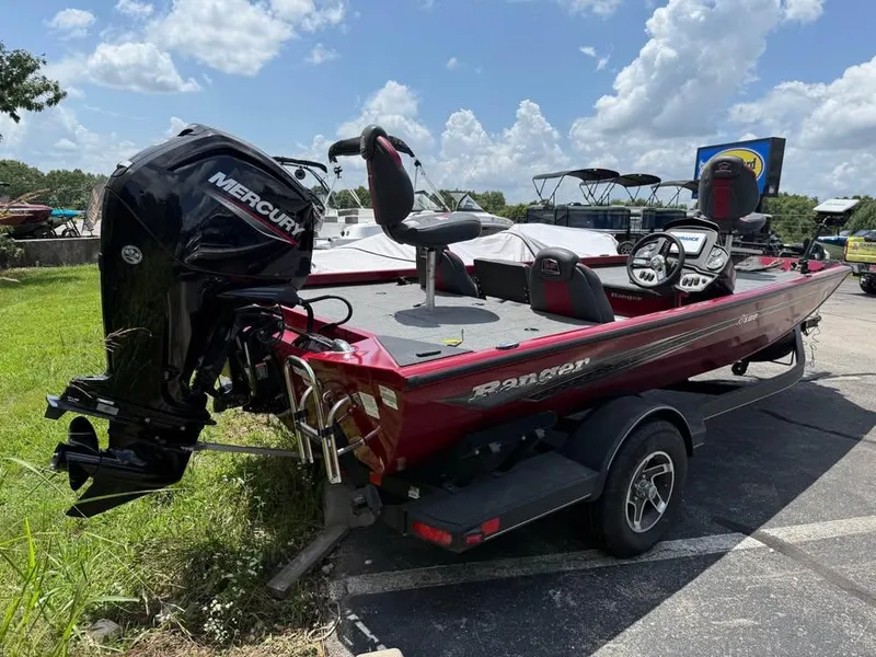Slide: The Image of 2023 Ranger RT 188 boat with Mercury engine, parked outdoors under a cloudy sky. - 6