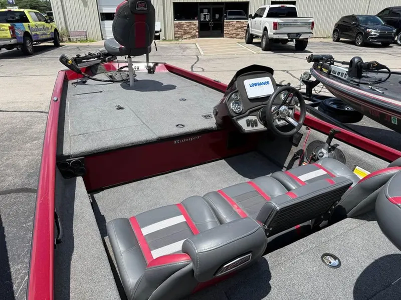 Slide: The Image of 2023 Ranger RT 188 boat interior with steering console and seating, parked outdoors. - 7