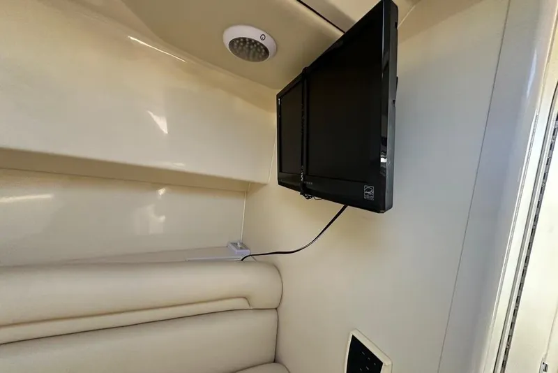 Slide: The Image of Interior of 2009 Boston Whaler 285 Conquest with mounted TV and cushioned seating. - 10