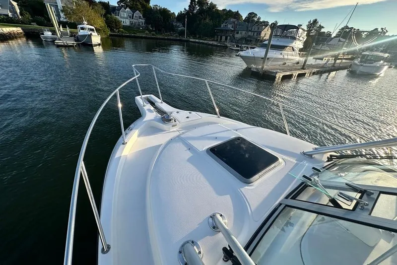 Slide: The Image of 2009 Boston Whaler 285 Conquest boat docked in a scenic marina setting. - 16