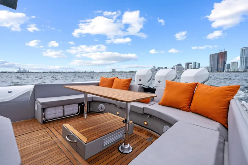 Slide: The Image of Luxurious 2021 Magazzu TARGA 45 yacht with elegant seating, orange cushions, and city skyline view. - 20