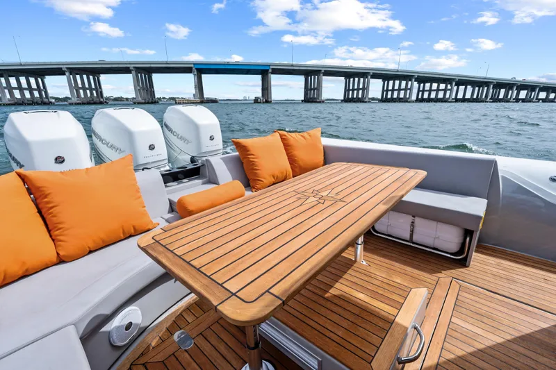 Slide: The Image of Luxurious 2021 Magazzu TARGA 45 yacht with wooden deck, orange cushions, and scenic bridge view. - 23