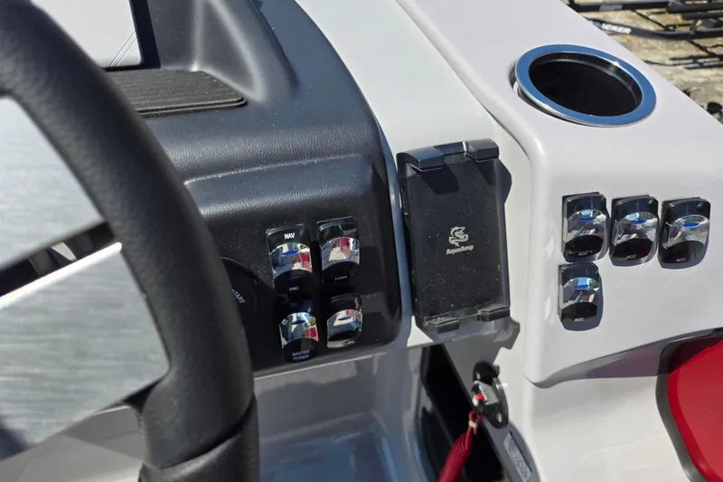 Slide: The Image of Control panel of 2026 Harris Cruiser 230 boat with switches and cup holder. - 18