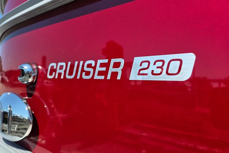 Slide: The Image of 2026 Harris Cruiser 230 boat logo on a shiny red surface. - 39