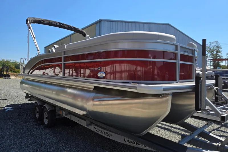 Slide: The Image of 2026 Harris Cruiser 230 pontoon boat on trailer, parked outdoors. - 8