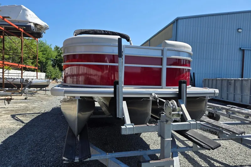 Slide: The Image of 2026 Harris Cruiser 230 pontoon boat on trailer, red exterior, parked outdoors. - 9