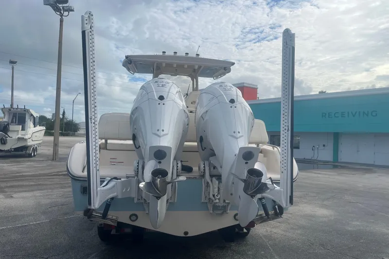 Slide: The Image of 2023 Grady-White 281 Coastal Explorer boat with dual outboard engines, parked outdoors. - 4