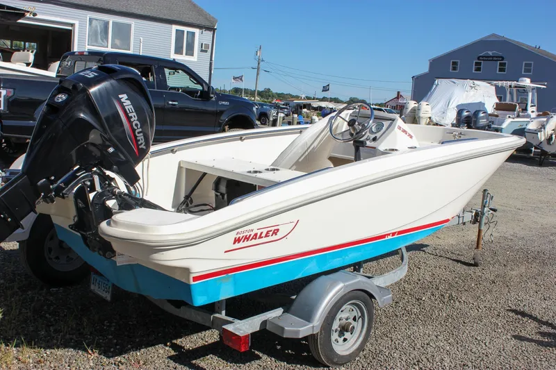 The Image of 2021 Boston Whaler 130 Super Sport boat on trailer, featuring Mercury outboard motor. - 0