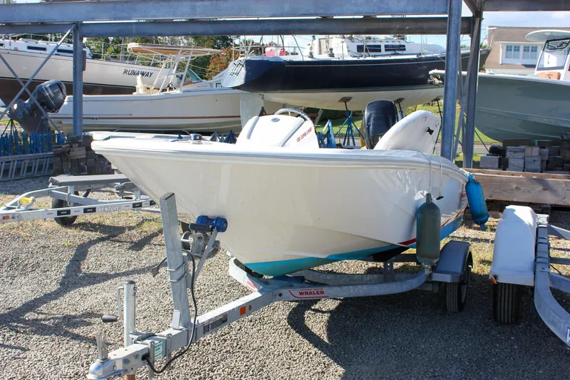 Slide: The Image of 2021 Boston Whaler 130 Super Sport boat on trailer in storage yard. - 1