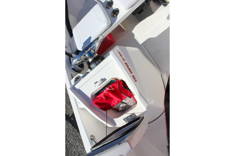 Slide: The Image of 2021 Boston Whaler 130 Super Sport interior with red bag and steering wheel. - 11