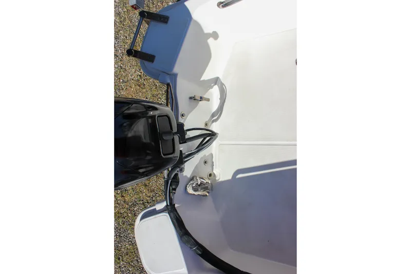 Slide: The Image of 2021 Boston Whaler 130 Super Sport boat interior with motor and deck details. - 15