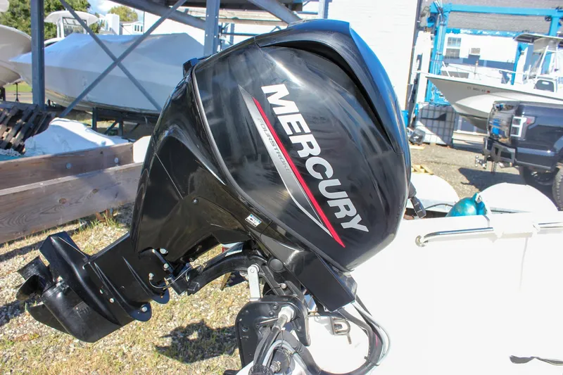 Slide: The Image of 2021 Boston Whaler 130 Super Sport with Mercury outboard motor in a marina setting. - 17