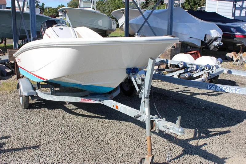 Slide: The Image of 2021 Boston Whaler 130 Super Sport boat on trailer, parked outdoors. - 2