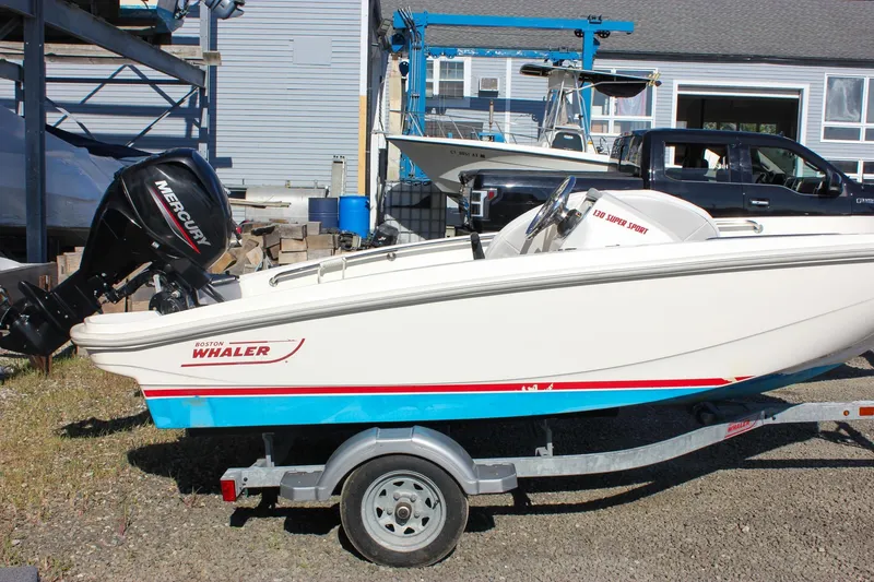 Slide: The Image of 2021 Boston Whaler 130 Super Sport boat on trailer with Mercury engine. - 3