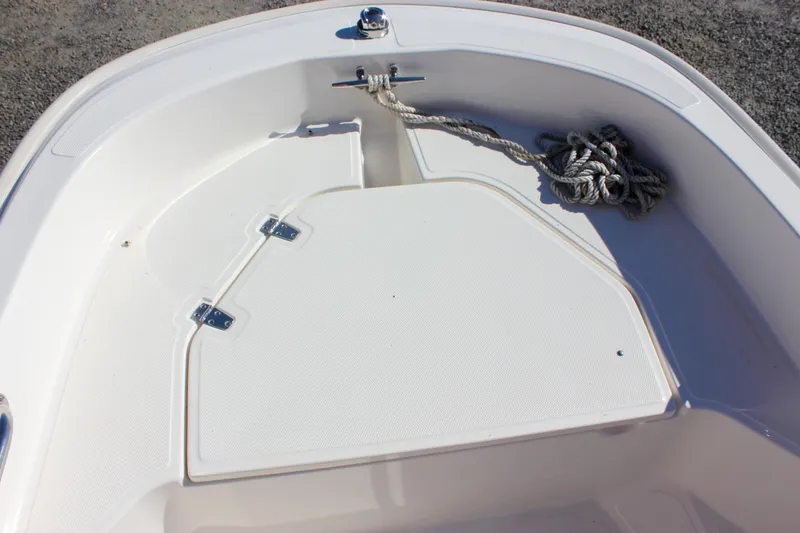 Slide: The Image of 2021 Boston Whaler 130 Super Sport boat deck with storage compartment and rope. - 6