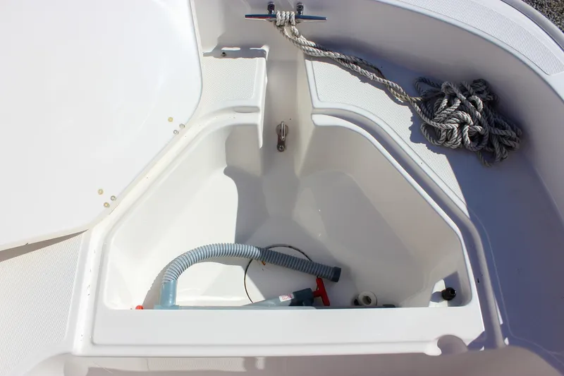 Slide: The Image of Open storage compartment on a 2021 Boston Whaler 130 Super Sport boat with rope and hose. - 7