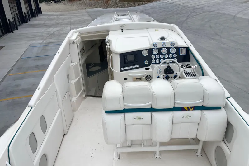 Slide: The Image of 1998 Nor-Tech 5000V Diesel boat cockpit with white seating and control panel. - 15