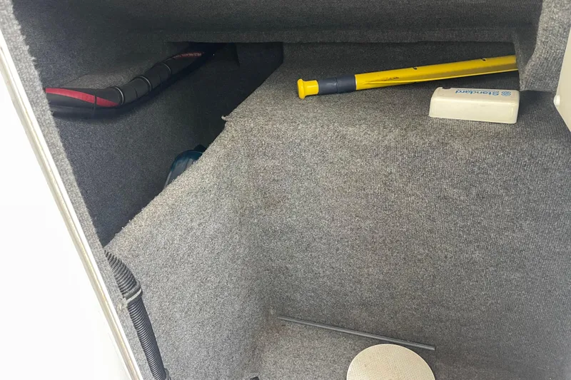 Slide: The Image of Interior storage compartment of a 1998 Nor-Tech 5000V Diesel boat with tools and equipment. - 35