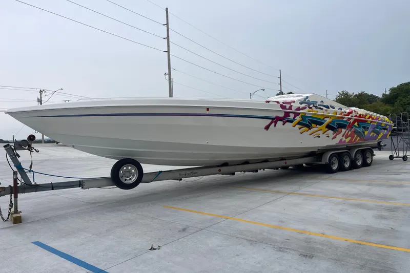 Slide: The Image of 1998 Nor-Tech 5000V Diesel boat with colorful graphics on a trailer in a parking lot. - 9