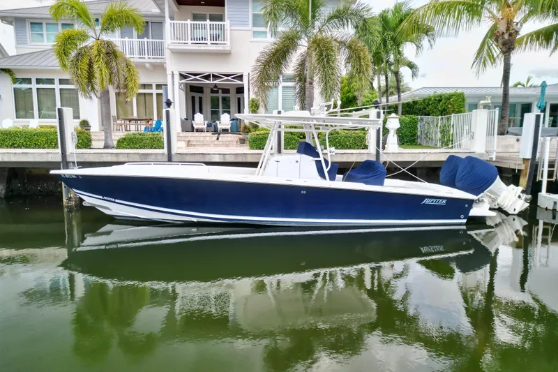 The Image of 2007 Jupiter 31 boat docked by waterfront home with palm trees. - 1