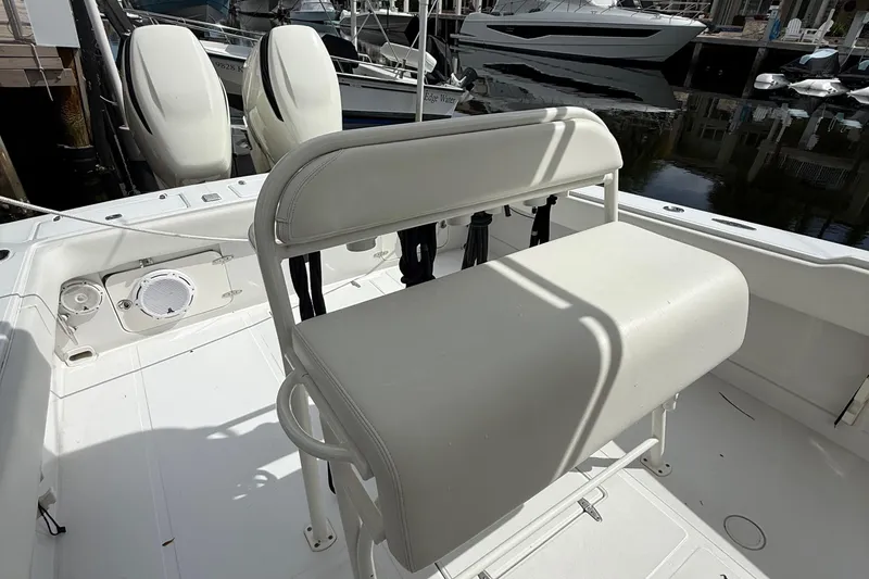 Slide: The Image of 2007 Jupiter 31 boat interior with white seating and dual engines at dock. - 14