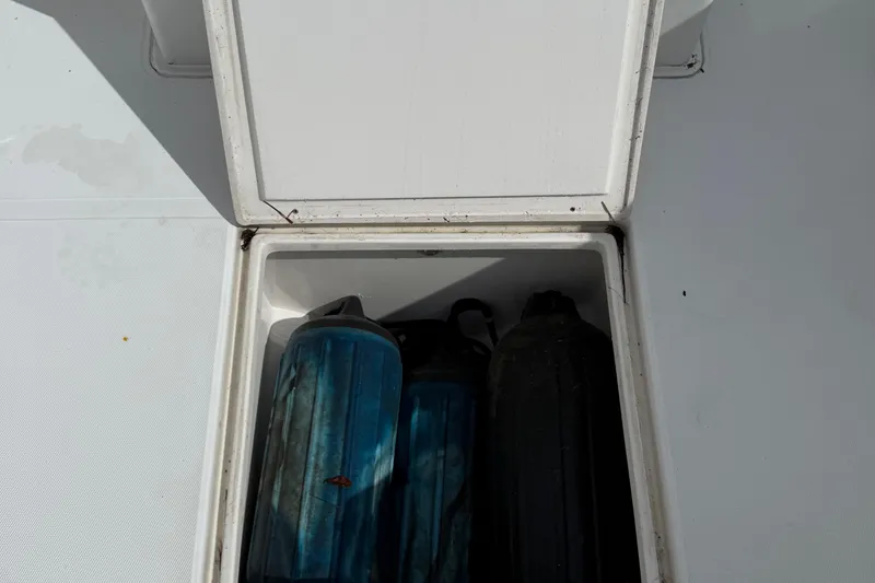 Slide: The Image of Open storage compartment on 2007 Jupiter 31 boat with blue and black fenders inside. - 20