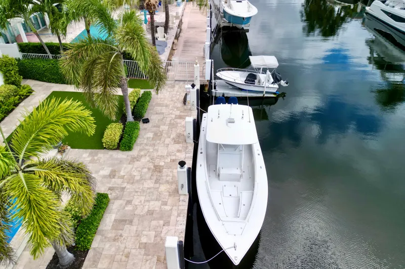 Slide: The Image of Aerial view of a 2007 Jupiter 31 boat docked by a lush, tropical waterfront. - 5