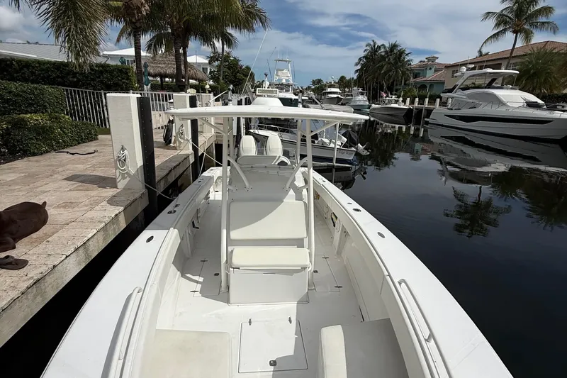 Slide: The Image of 2007 Jupiter 31 boat docked in a scenic marina with palm trees and yachts. - 7