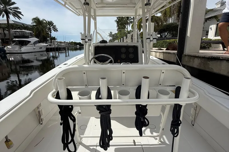 Slide: The Image of 2007 Jupiter 31 boat interior with rod holders and ropes, docked near palm trees. - 8