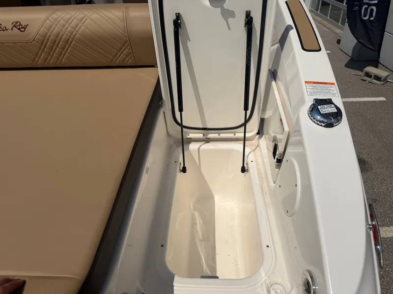 Slide: The Image of The image shows the storage compartment of a 2026 Sea Ray SDX 250 Outboard with beige upholstery. - 21