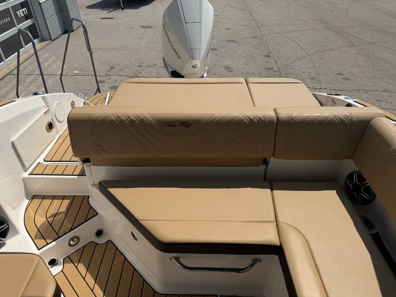 Slide: The Image of The image shows the stern of a Sea Ray SDX 250 Outboard with beige upholstery and wood flooring. - 35