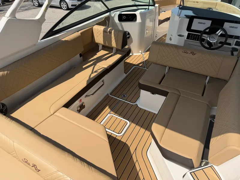 Slide: The Image of The image shows the interior of a 2026 Sea Ray SDX 250 Outboard with beige seating and wood flooring. - 32