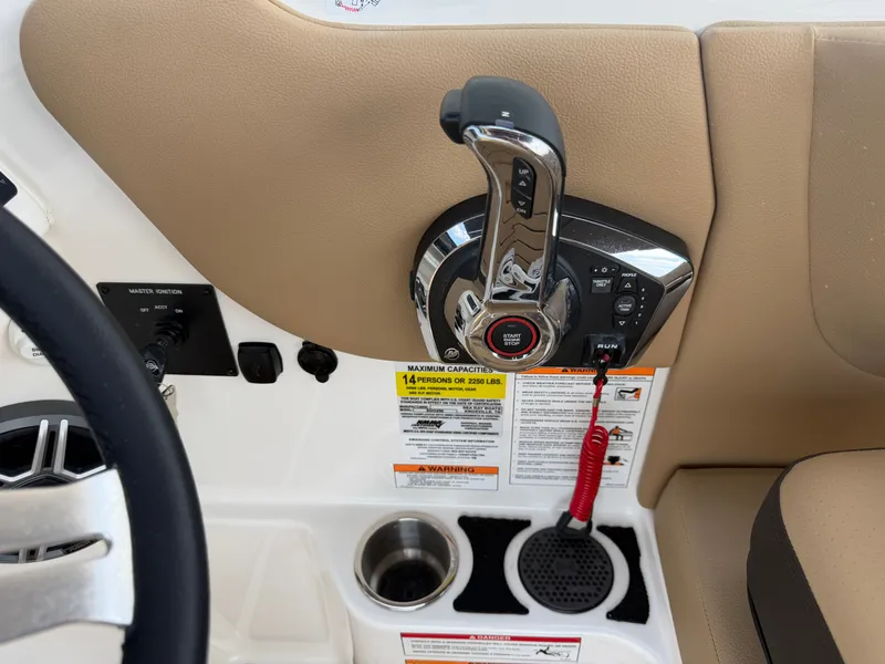 Slide: The Image of Close-up of the helm area on a Sea Ray SDX 250 Outboard with controls and cup holders. - 44