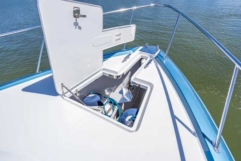 Slide: The Image of 2019 Palm Beach Motor Yachts GT50 anchor compartment with open hatch, on calm water. - 15