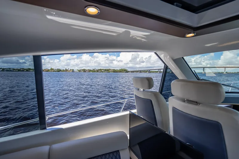 Slide: The Image of Interior view of 2019 Palm Beach Motor Yachts GT50, overlooking serene waters and bridge. - 25
