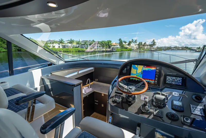 Slide: The Image of 2019 Palm Beach Motor Yachts GT50 helm with navigation screens and luxurious interior. - 29