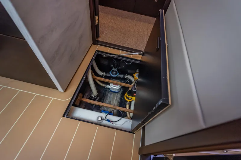 Slide: The Image of 2019 Palm Beach Motor Yachts GT50 interior showing open hatch with visible plumbing components. - 39