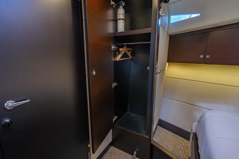 Slide: The Image of 2019 Palm Beach Motor Yachts GT50 interior closet with fire extinguisher and hangers. - 45